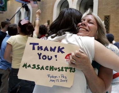 Two women hug in MA State House, holding sign reading "Thank You! Massachusetts Robyn & Peg May 17, 2004"